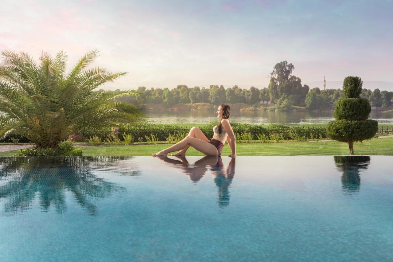 Jolie Ville Hotel & Spa Kings Island Louxor Extérieur photo A woman sitting on the edge of a pool